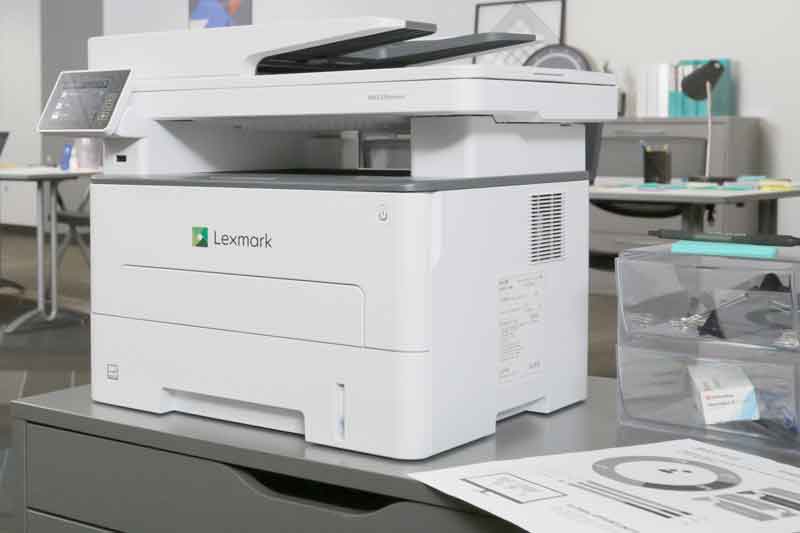Photo shows a printer located in small business back office. 