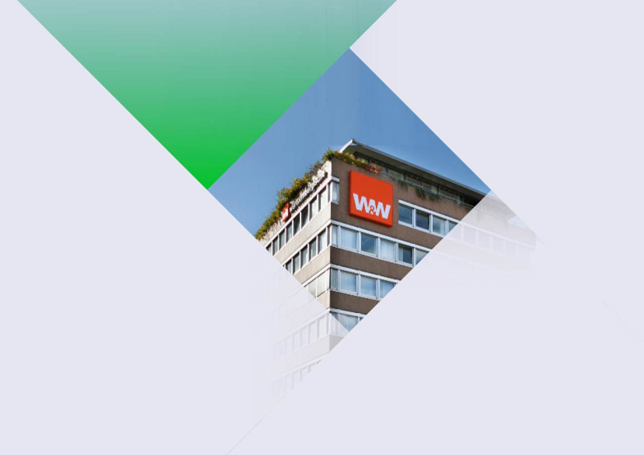 Three people in an office surrounded by computers talking.