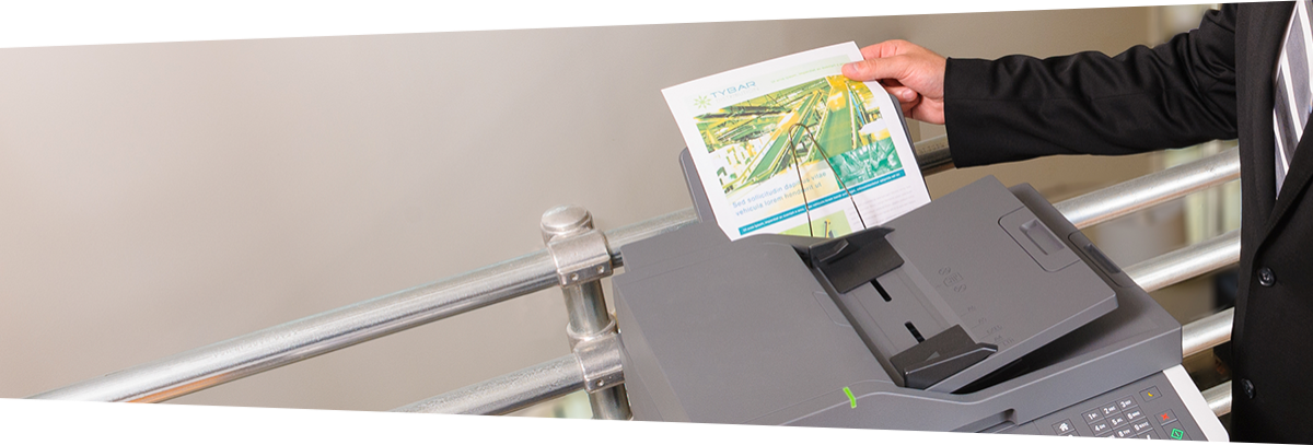 man pulling printed document from printer