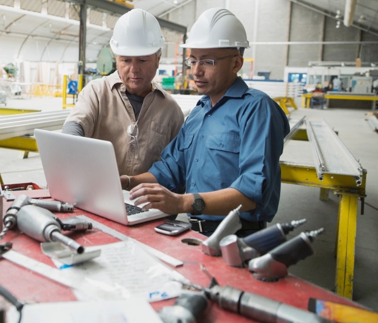 stock-photo-workers-at-laptop-in-manufacturing-plant-85464847